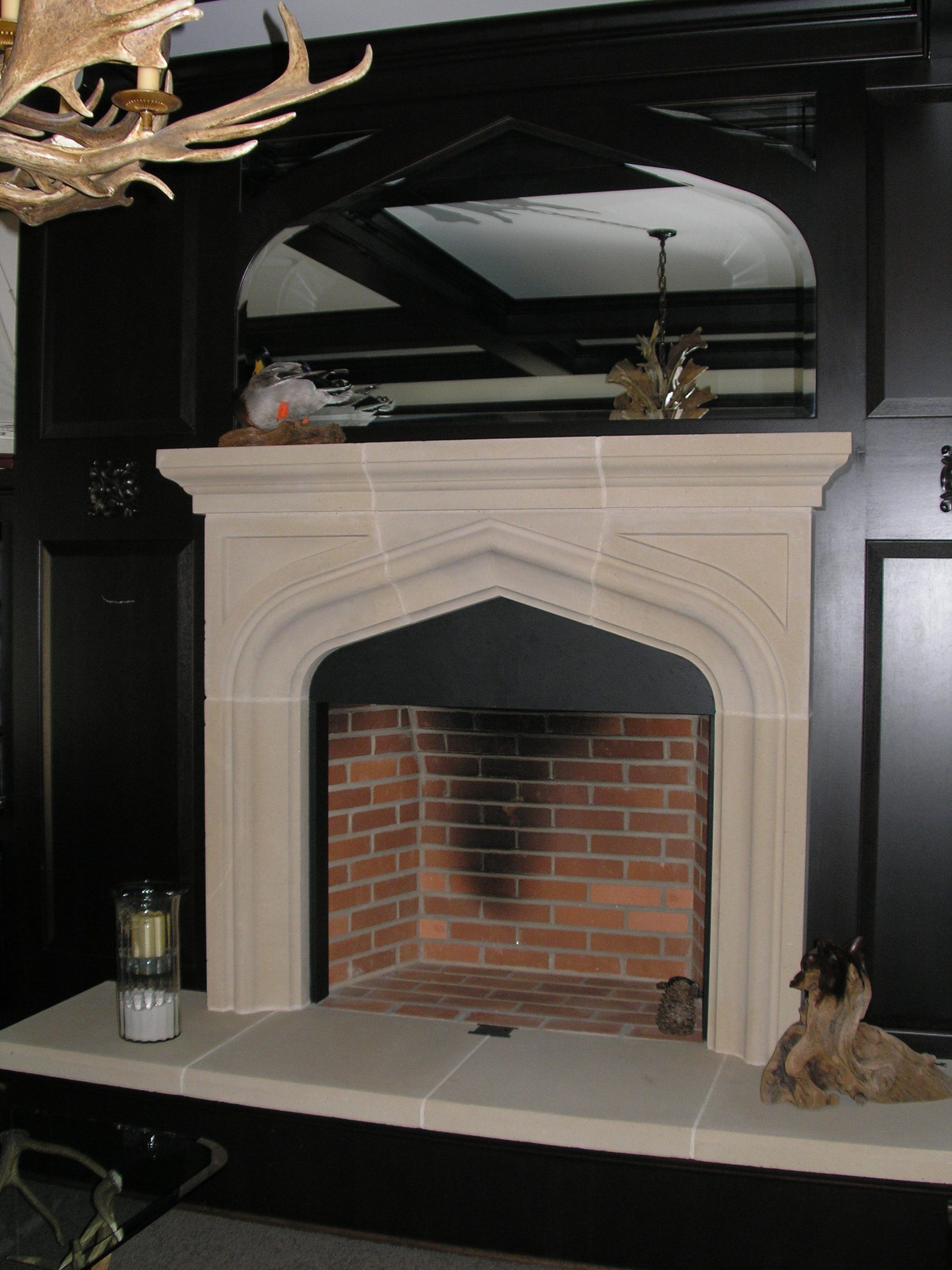 The second custom fireplace — a Tudor four-centred arch in cast plaster with a moulded mantel and overmantel mirror, over a brick firebox.