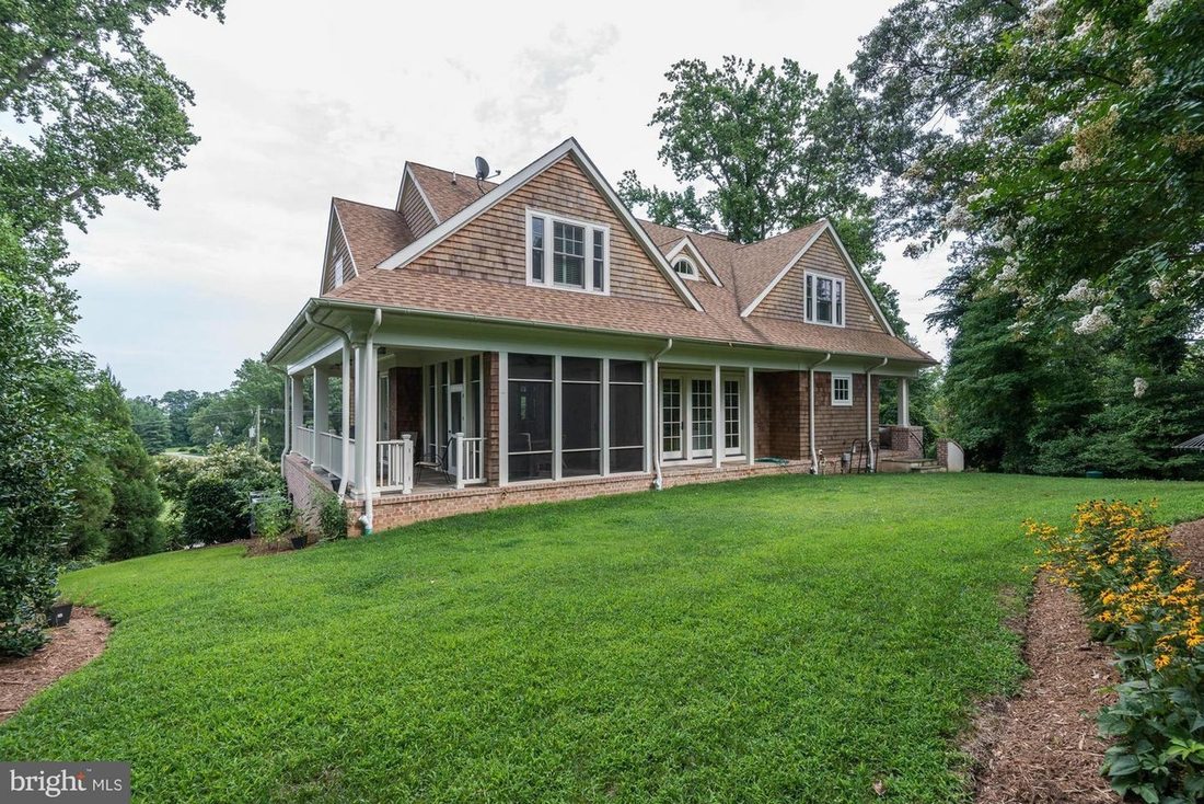 The rear elevation stepping down the slope, with stacked porches opening toward the Bay view.
