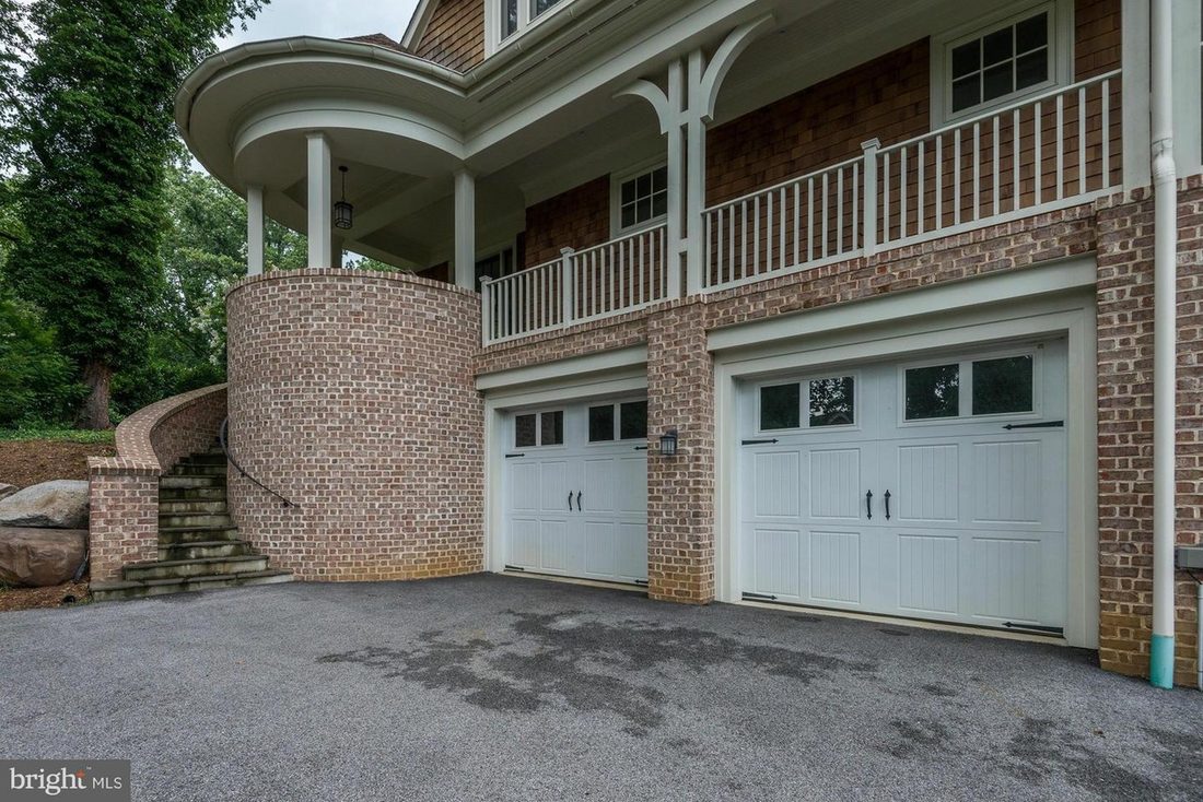 The garage entry wing, with shingle siding, white trim and stone detailing.