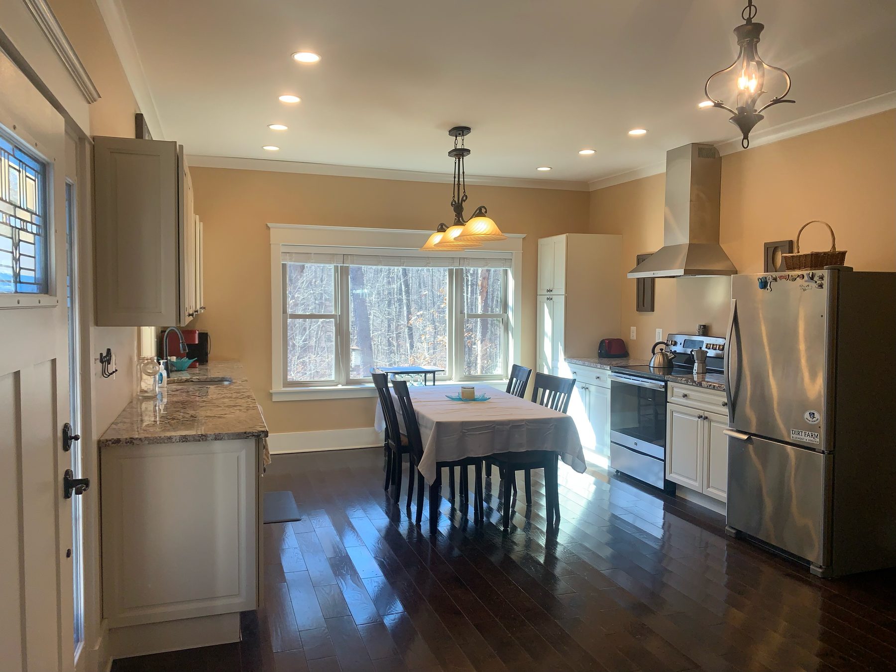 The open kitchen and dining area — light maple cabinets, a window over the sink and a single-level layout flowing to the living room.